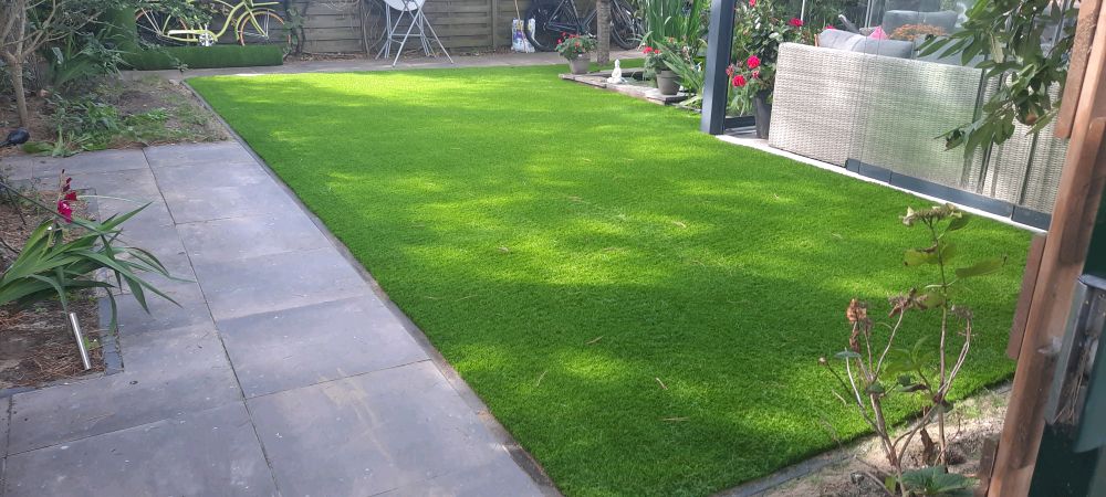 Derselbe Garten nach der Verlegung: gepflegter grüner Kunstrasen