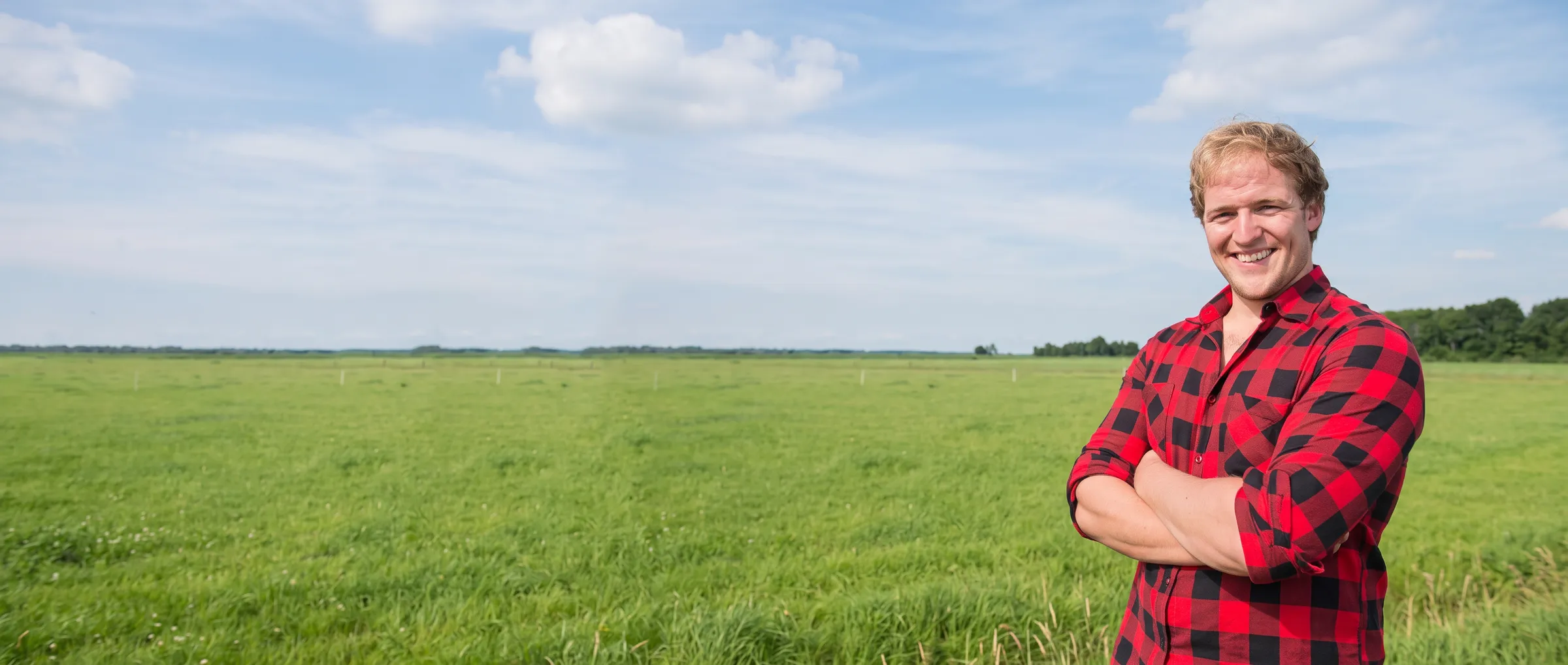Mitarbeiter von Kunstrasenbauer im karierten Hemd auf einer holländischen Weide